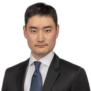 A headshot of Wansoo Pak, PhD wearing a black suit with a slate blue tie