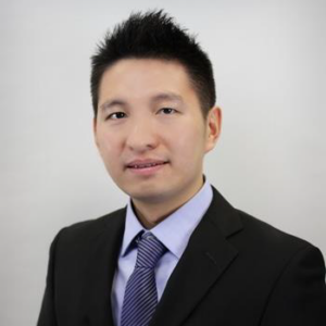 A headshot Zhongyuan Qian, PhD-PE in a black suit, light purple shirt and navy and purple stripped tie.